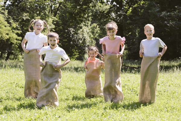 Enfants qui font une course en sac