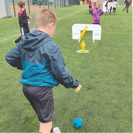 Jeune garçon jouant à Footigolf Club pendant un entrainement de foot